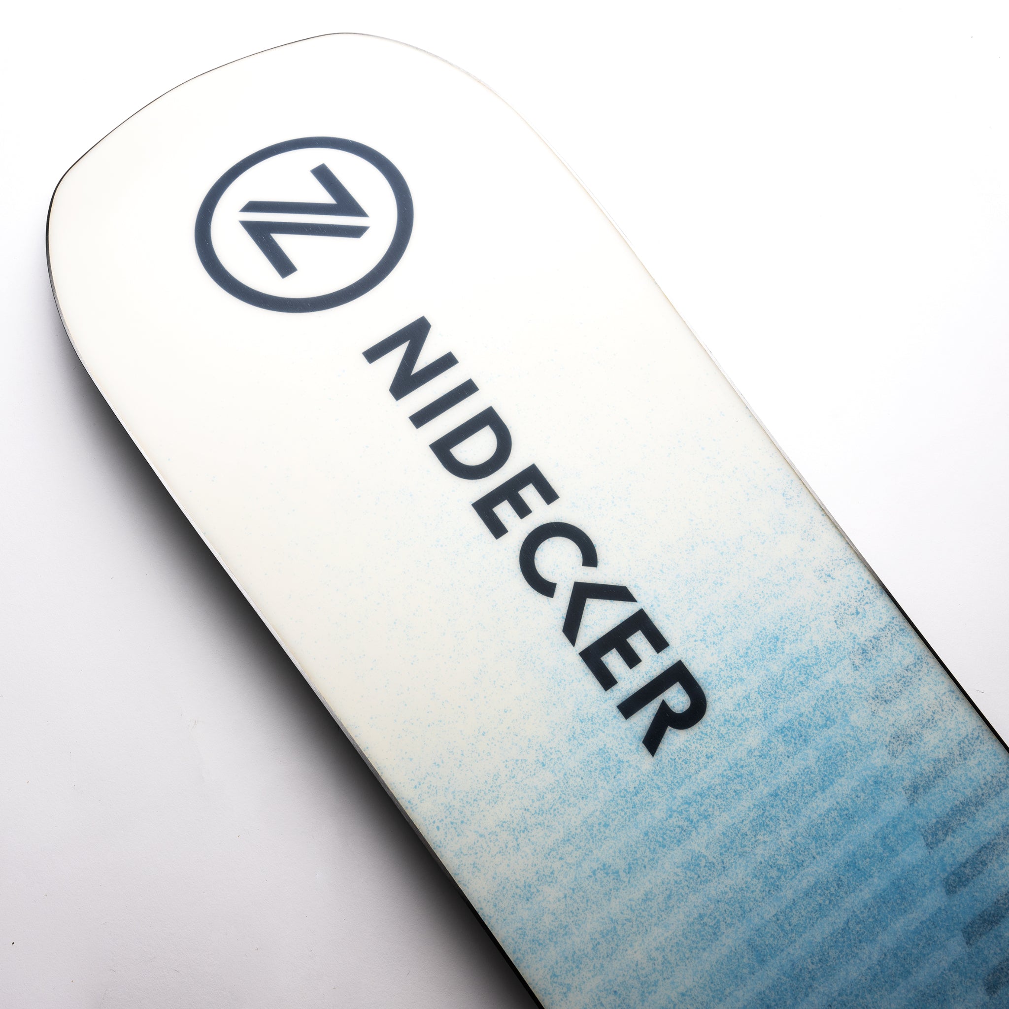 Nidecker Play Snowboard 2025 - A white snowboard with a blue patterned design on its bottom.