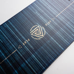 Nidecker Play Snowboard 2025 - A dark blue snowboard with a white logo featuring a stylized "P" and a circular design, set against a light gray background.