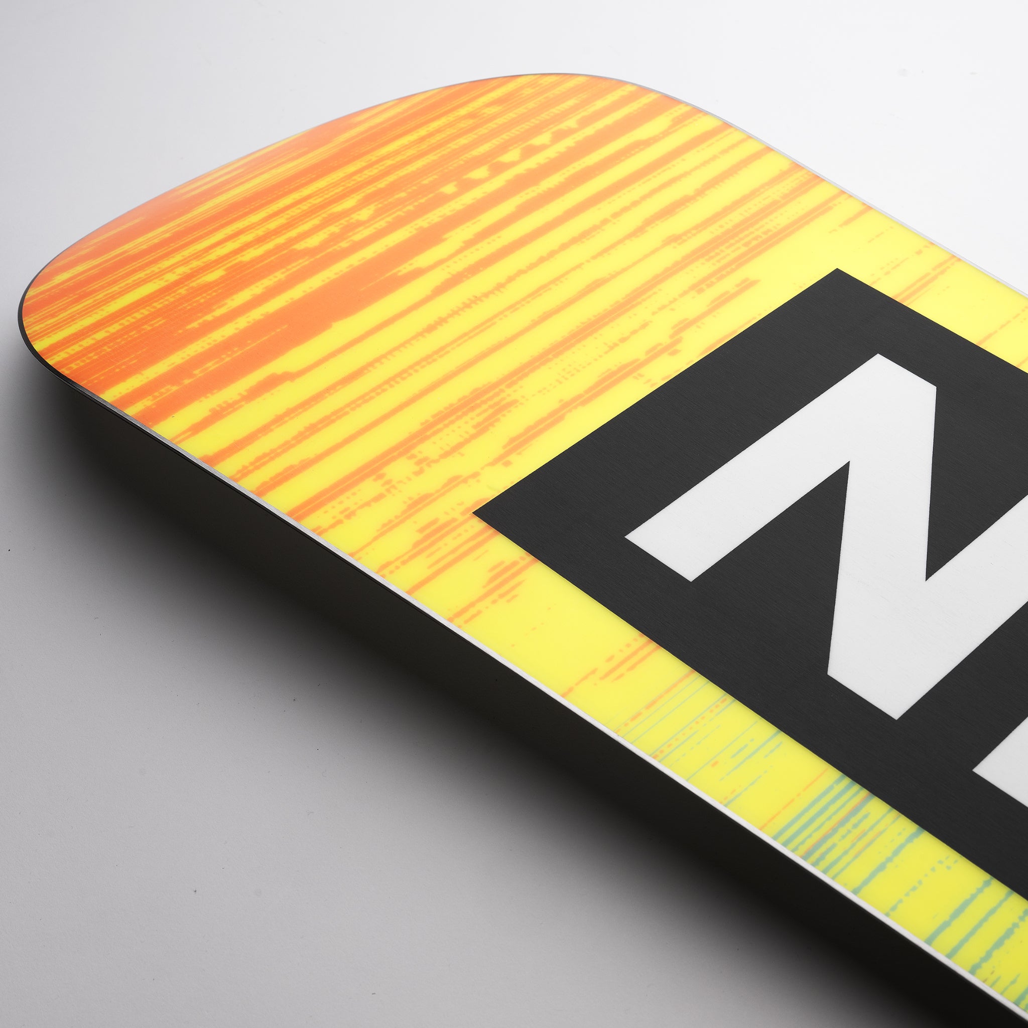 Nidecker Sensor Pro Snowboard 2025 - A yellow snowboard with orange stripes and a black logo on top.