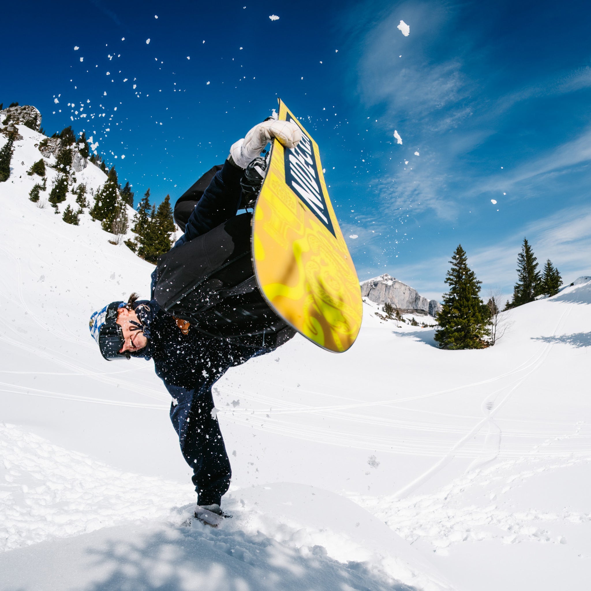 Nidecker Sensor Team Snowboard 2025 - A yellow snowboard with a black logo and white lettering, featuring a blue pattern on its underside.