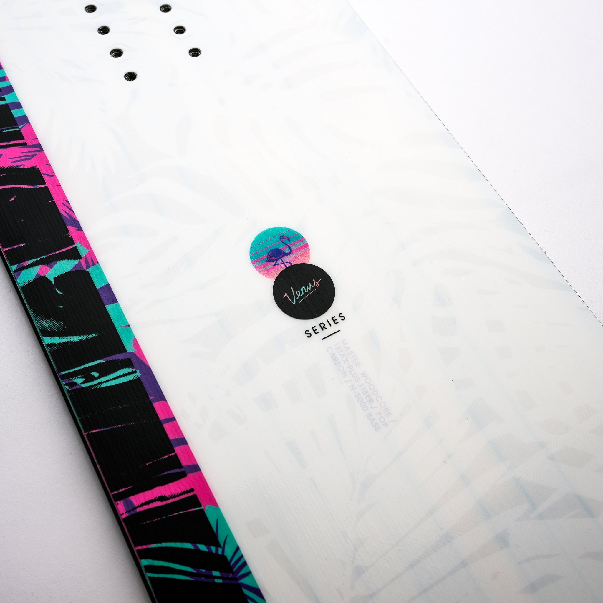 Nidecker Venus Women's Snowboard 2025 - A white snowboard with a pink and purple palm tree pattern on the top sheet, featuring a black base.