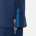 Rossignol Men's Blackside Insulated Jacket - A black jacket with a zippered chest pocket and two zippered side pockets, featuring a Rossignol logo on the left sleeve.