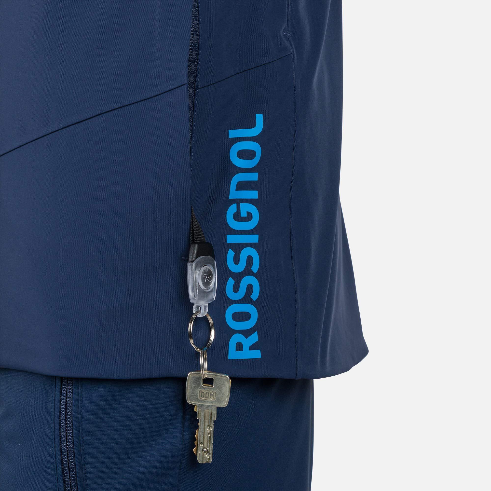 Rossignol Men's Blackside Insulated Jacket - A black jacket with a zippered chest pocket and two zippered side pockets, featuring a Rossignol logo on the left sleeve.