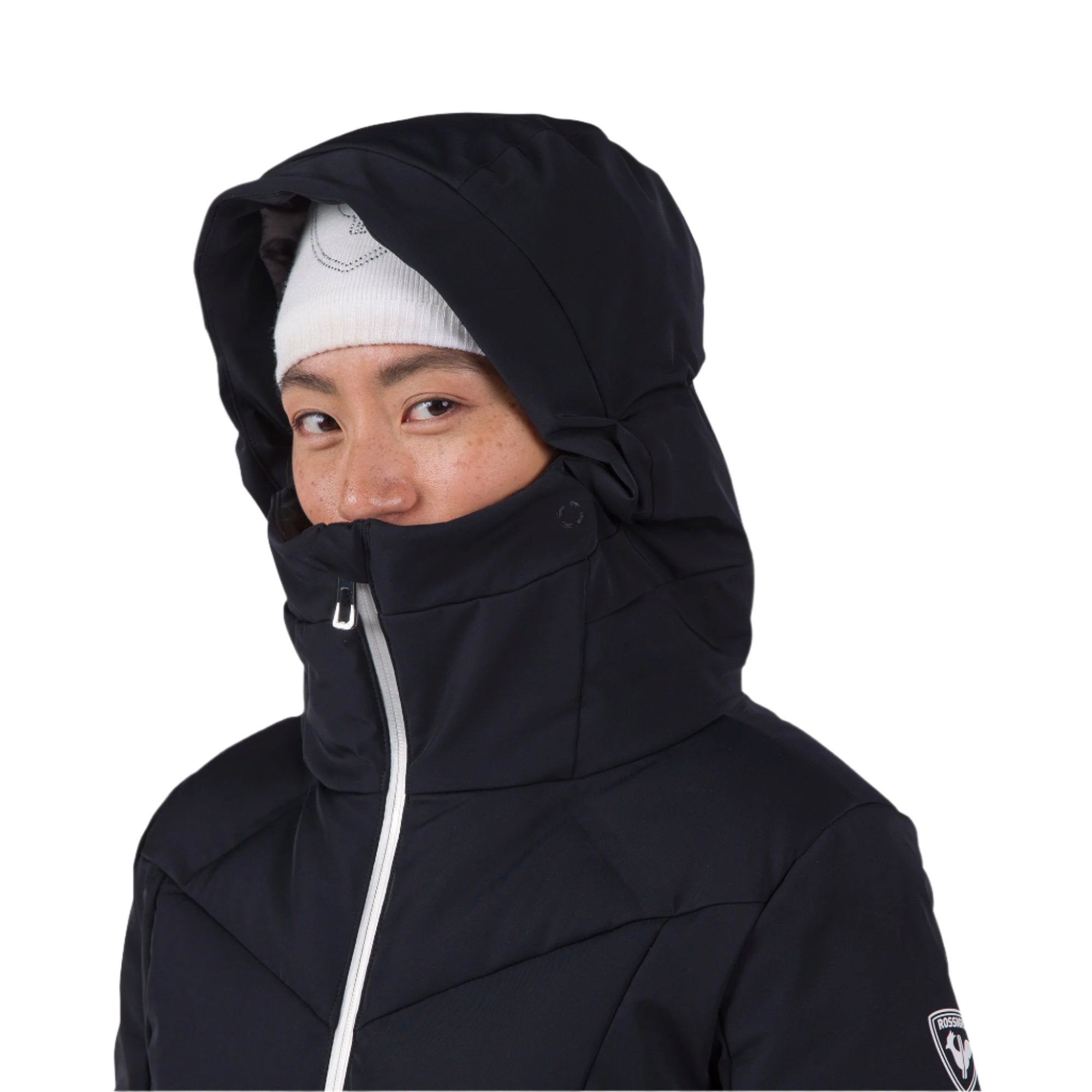 Rossignol Women's Blackside Puffy Jacket 2025 - A black puffer jacket with a hood, featuring a white zipper and a Rossignol logo on the left sleeve.