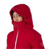 Rossignol Women's Blackside Puffy Jacket - A black puffy jacket with a hood, featuring a zipper down the front and two zippered pockets on either side.