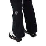 Rossignol Women's Blackside Insulated Pant 2025 - A pair of black ski pants with a white logo on the left thigh and a white zipper pull on the right leg.