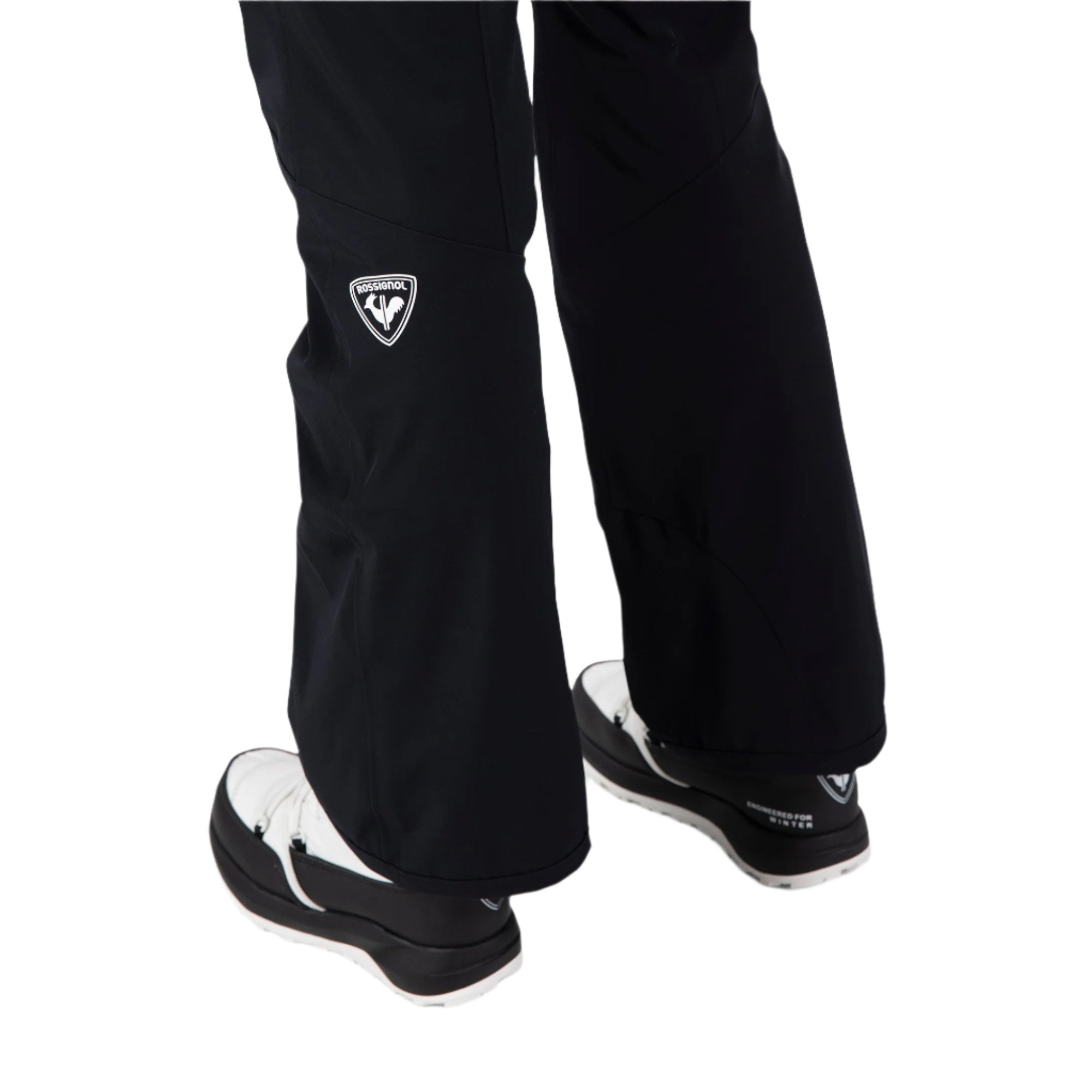 Rossignol Women's Blackside Insulated Pant 2025 - A pair of black ski pants with a white logo on the left thigh and a white zipper pull on the right leg.