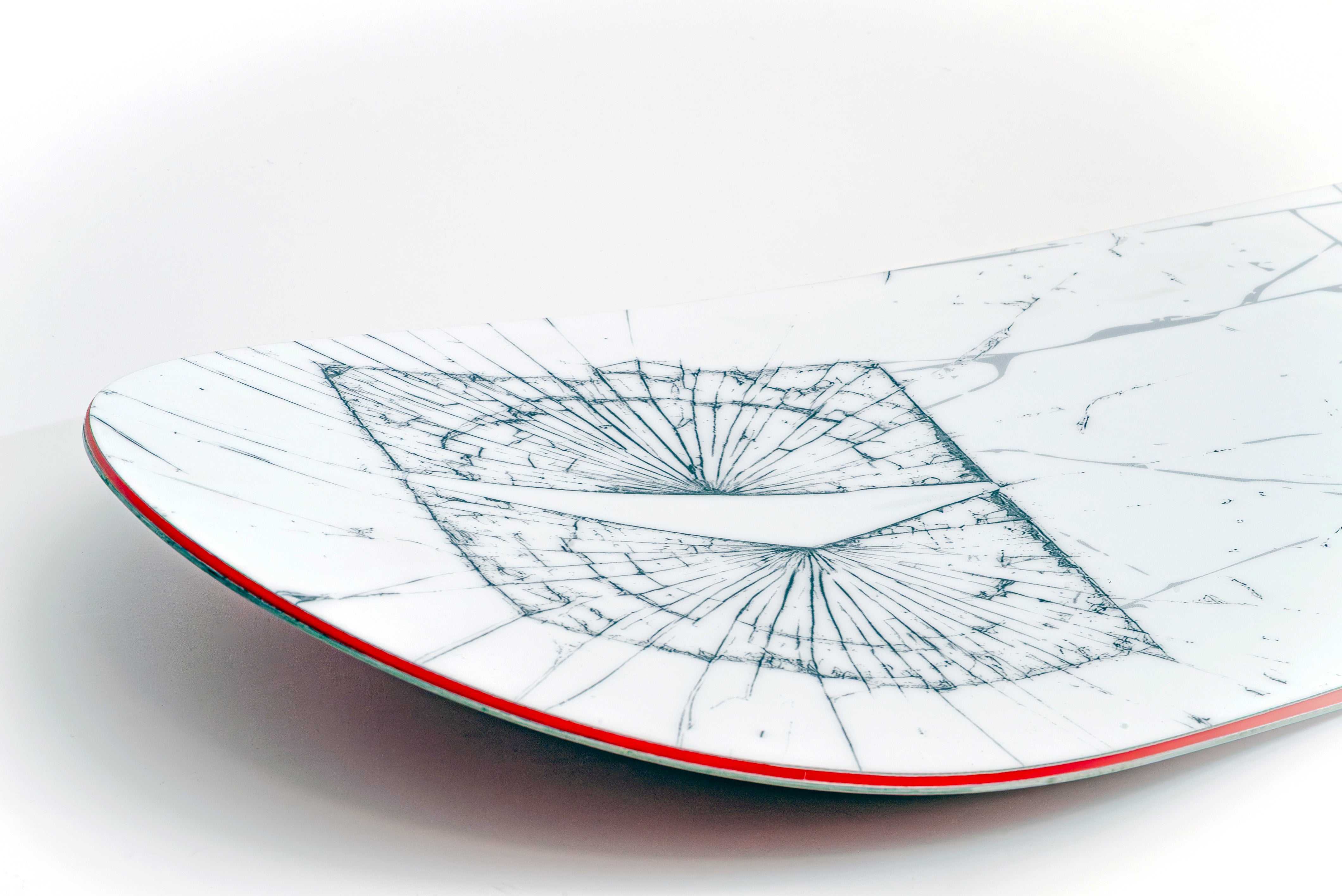 White snowboard with blue line-map graphic and red edge stripe.