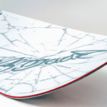 White snowboard with blue signature-style graphic and red sidewall line.