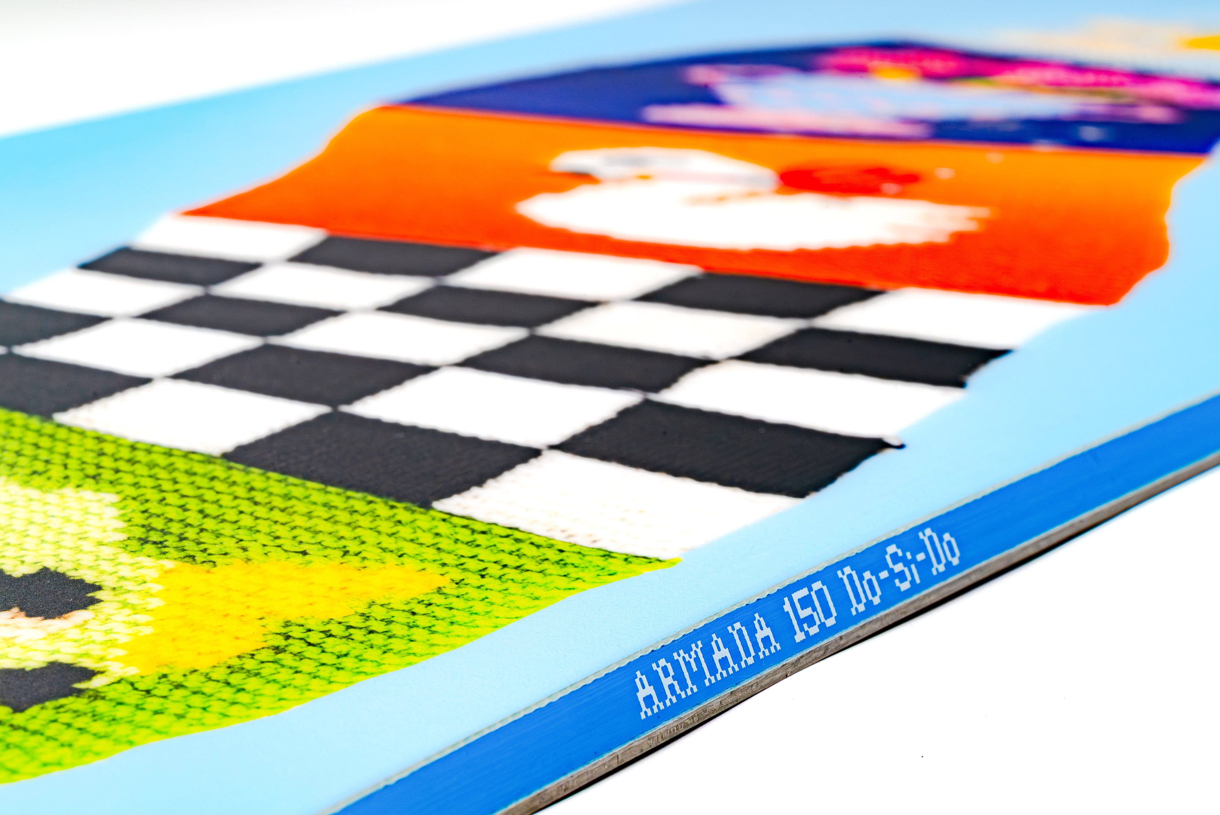 Snowboard deck with black checker stripe and bright orange graphic on light blue