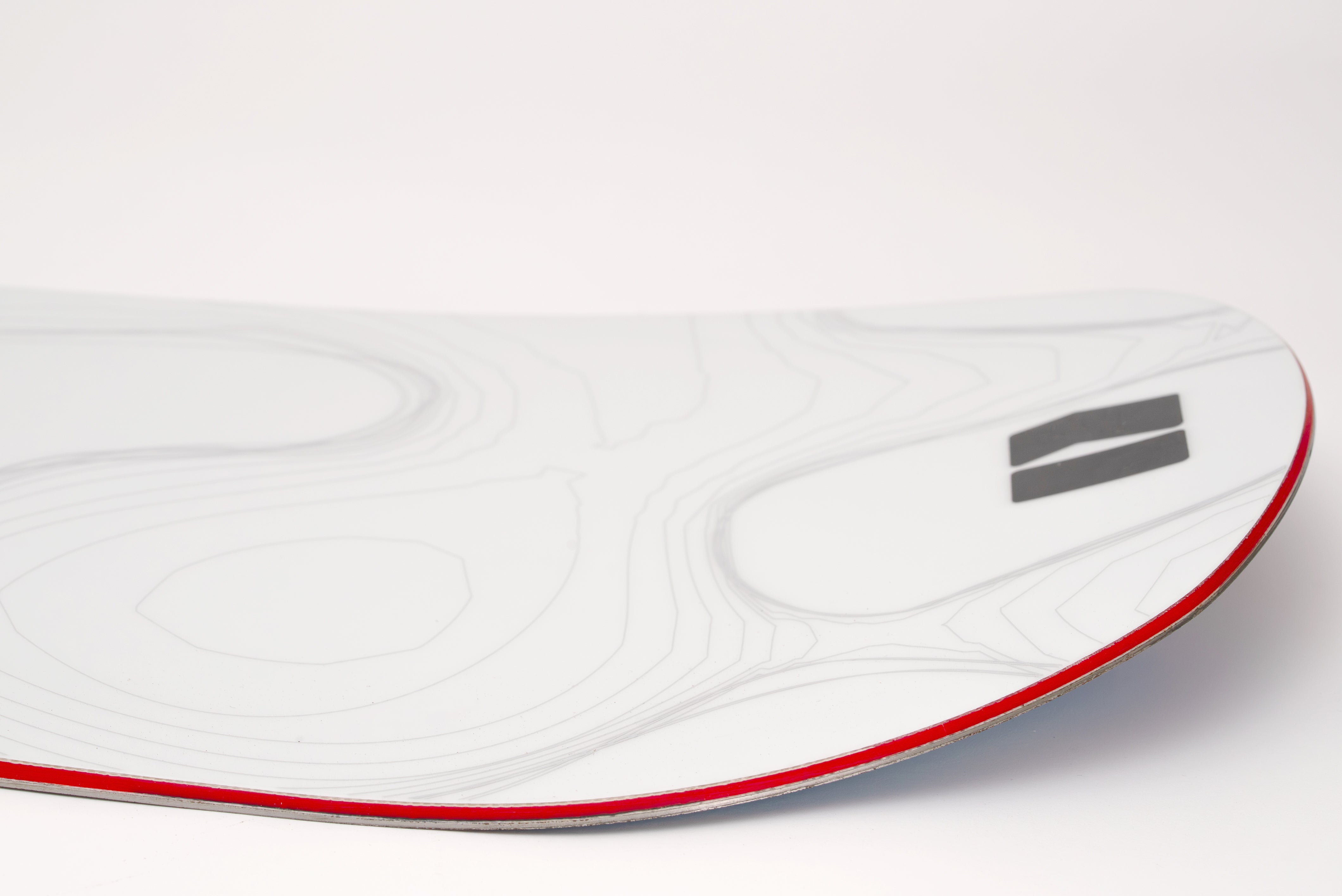 White snowboard with red edge stripe and black side logo