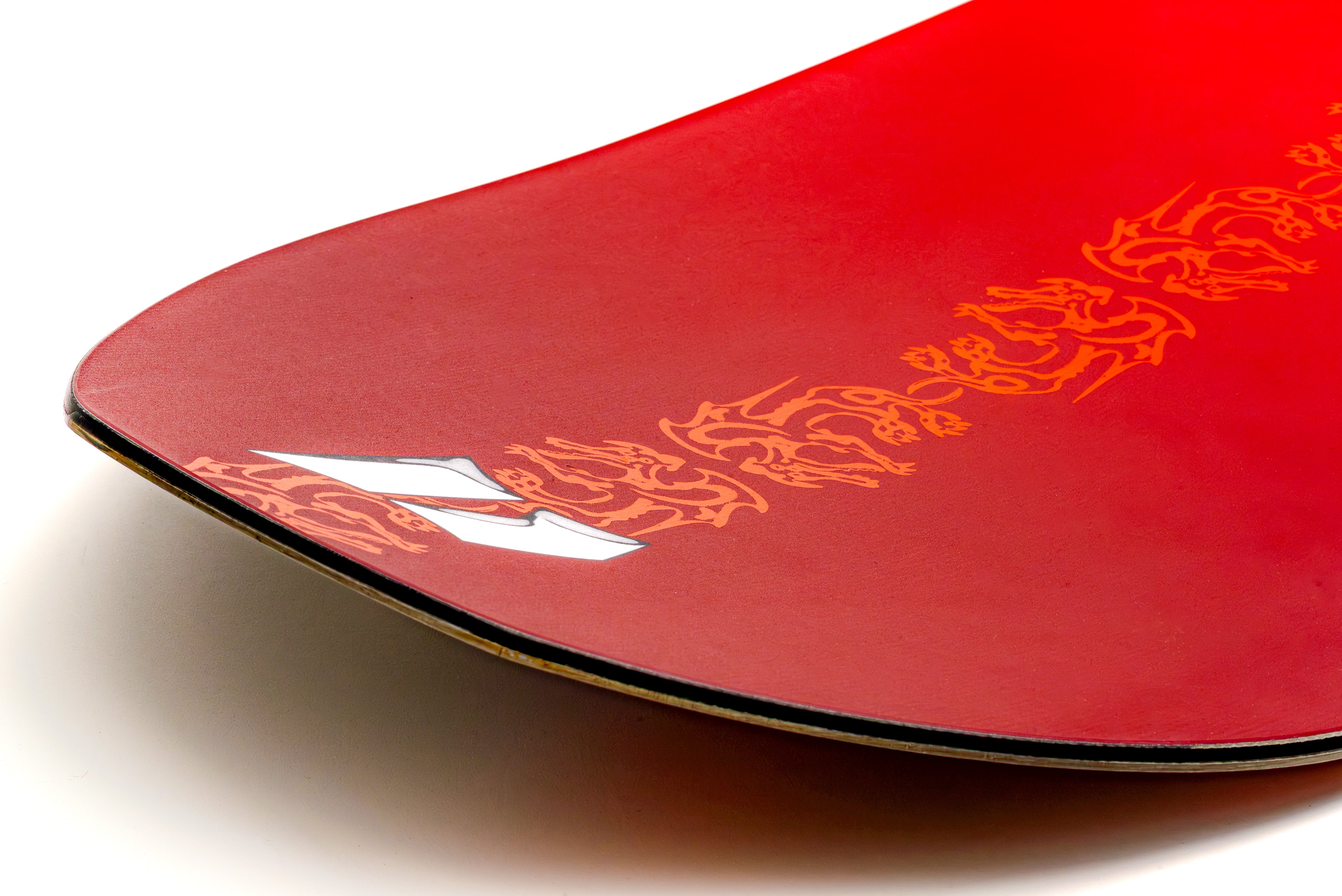 Red snowboard nose with yellow graphic accents along the edge