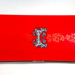 Red snowboard deck with central logo and decorative graphics