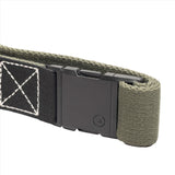 A close-up of an ivy green belt with a black patch, showing the buckle in its closed position. The buckle has a small logo, and the belt's stitching is visible.