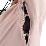 Airblaster Women's Stay Wild Insulated Jacket 2025 - A light pink jacket with a zipper and black drawstring on the hood, hanging from a black hanger against a white background.