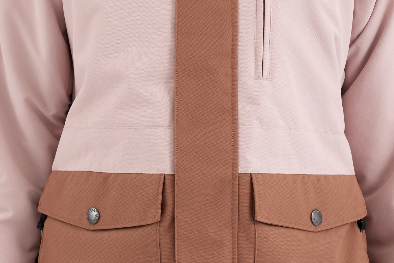 Airblaster Women's Stay Wild Insulated Jacket 2025 - A light pink jacket with a zippered chest pocket and two front pockets, featuring a subtle pattern of darker pink lines on the upper back.