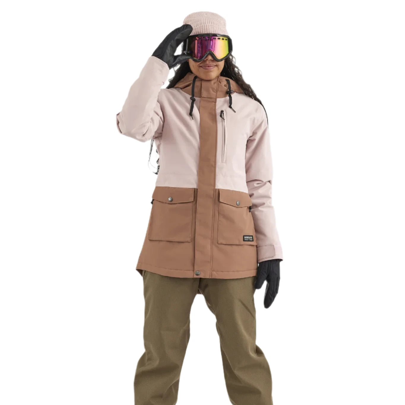 Airblaster Women's Stay Wild Insulated Jacket 2025 - A woman wearing a pink and brown jacket with two front pockets, black gloves, and goggles.