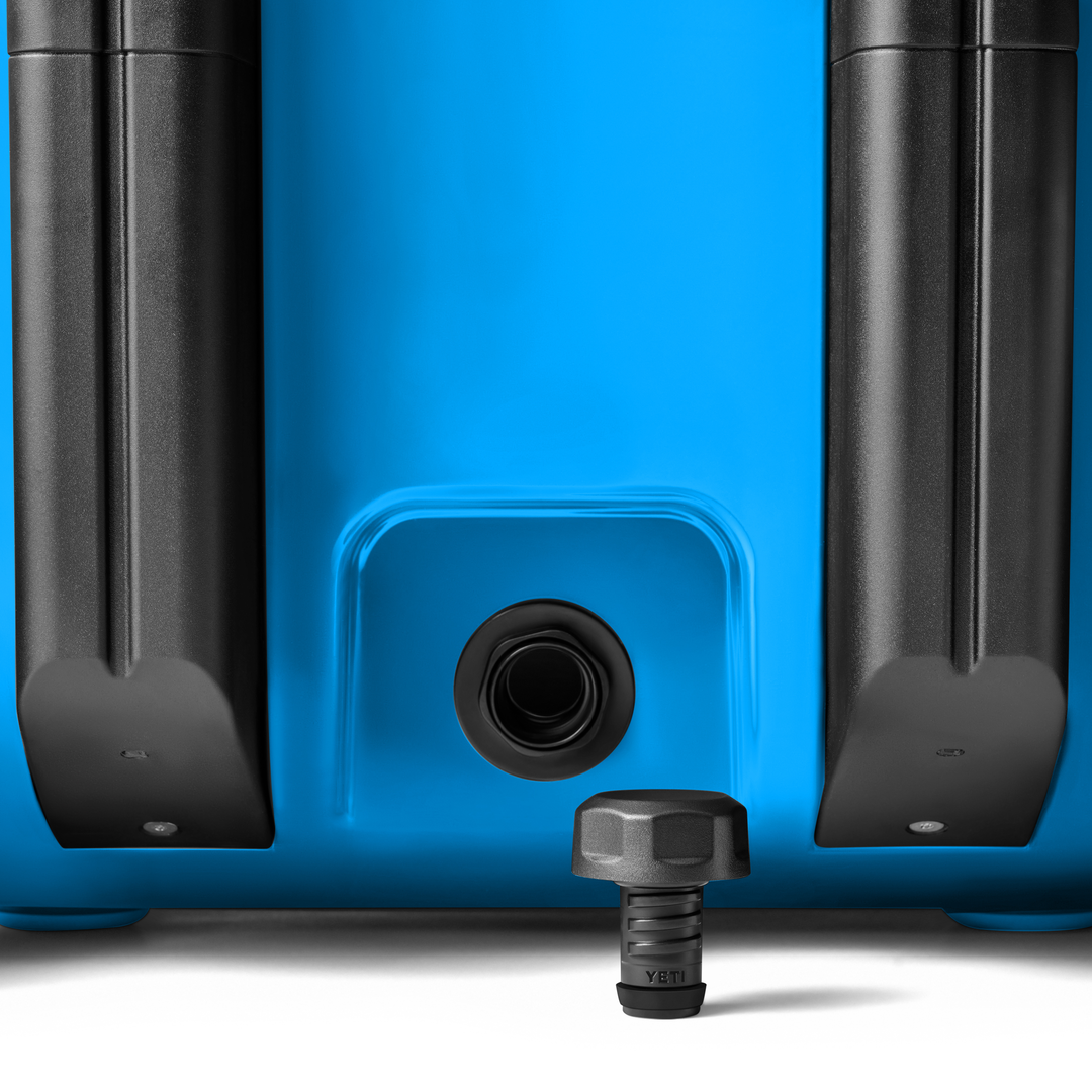 Yeti Roadie 48 Wheeled Cooler - A blue wheeled cooler with a black handle and wheels, featuring a circular drain plug at the bottom.