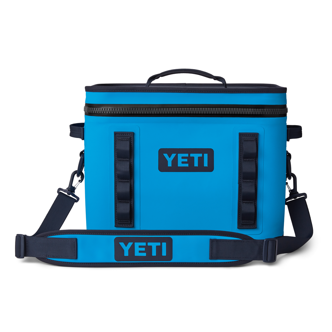 Yeti Hopper Flip 18 Personal Cooler - A blue cooler with a handle on top and two zipper compartments, one of which is open to reveal an ice pack inside.