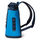Yeti Hopper M12 Backpack Soft Cooler - A blue backpack with a zippered top and two adjustable shoulder straps, featuring a large main compartment and a smaller front pocket.
