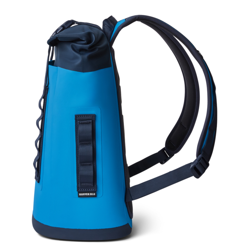 Yeti Hopper M12 Backpack Soft Cooler - A blue backpack with a zippered top and two adjustable shoulder straps, featuring a large main compartment and a smaller front pocket.