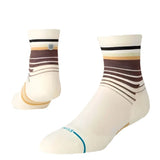 TRACKING QUARTER C SOCK 2025 - A pair of white socks with brown stripes and a blue stripe at the toe.