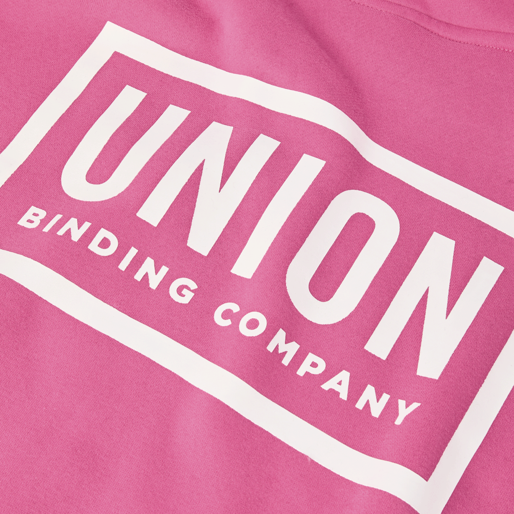 Union Team Hoodie - A pink hoodie with a white logo on the chest featuring a stylized "U" and "T".