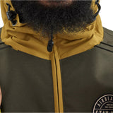 Airblaster Trenchover Half Zip Shell Jacket 2025 - A dark green jacket with a zippered front and two black drawstrings at the hood.