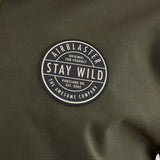 Airblaster Trenchover Half Zip Shell Jacket 2025 - Olive green jacket with a round logo on the chest featuring white and black lettering.