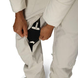 Close-up of off-white insulated bib overalls with black inner gaiter and side zipper opening.