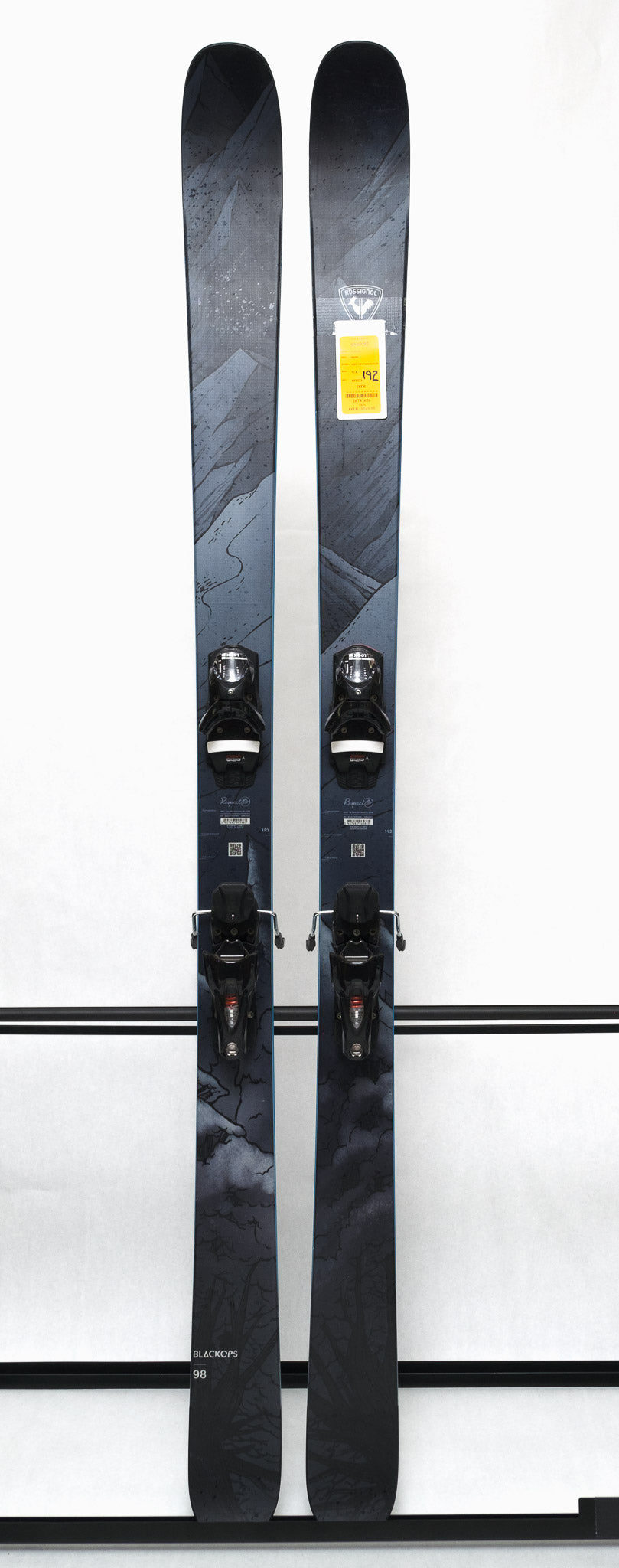 USED - Rossignol Blackops 98 with SPX 12 Demo Bindings - A pair of skis with a black and white marbled pattern on the tops, featuring a distinctive "Blackops" logo in silver.