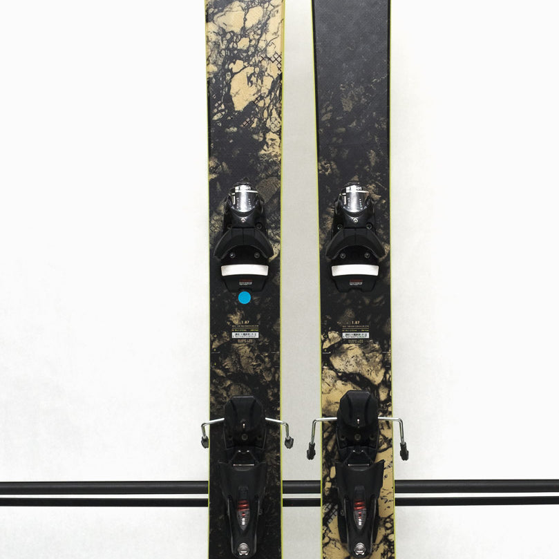 USED - Rossignol Black Ops Sender Ti with SPX 12 Bindings - A black ski with a yellow sticker on its tip and silver bindings.