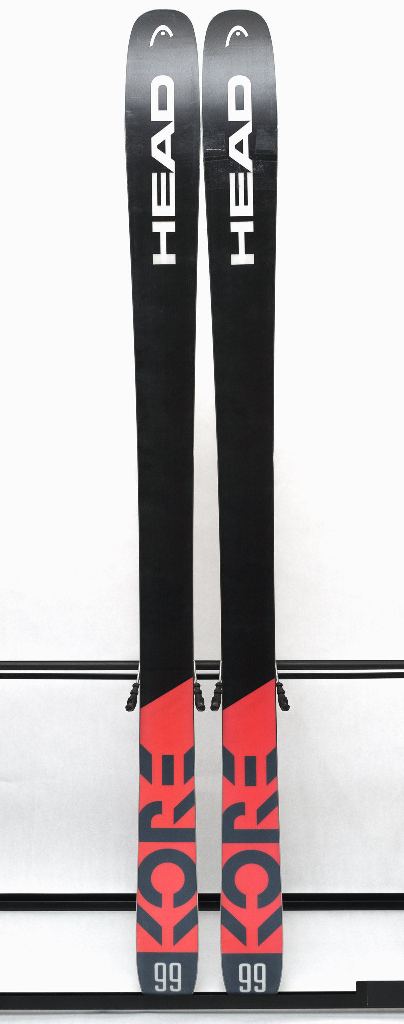 USED - Head Kore 99 with Attack 14 Bindings - A pair of skis with a black base and white lettering, featuring the word "HEAD" on one ski and "KORE" on the other.