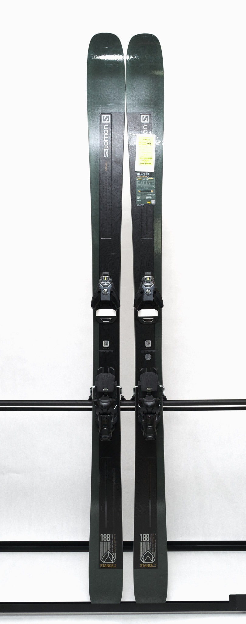 USED - Salomon Stance 90 2022 with STH13 Bindings - A pair of skis and bindings, featuring a dark gray color scheme with white lettering on the Salomon logo.