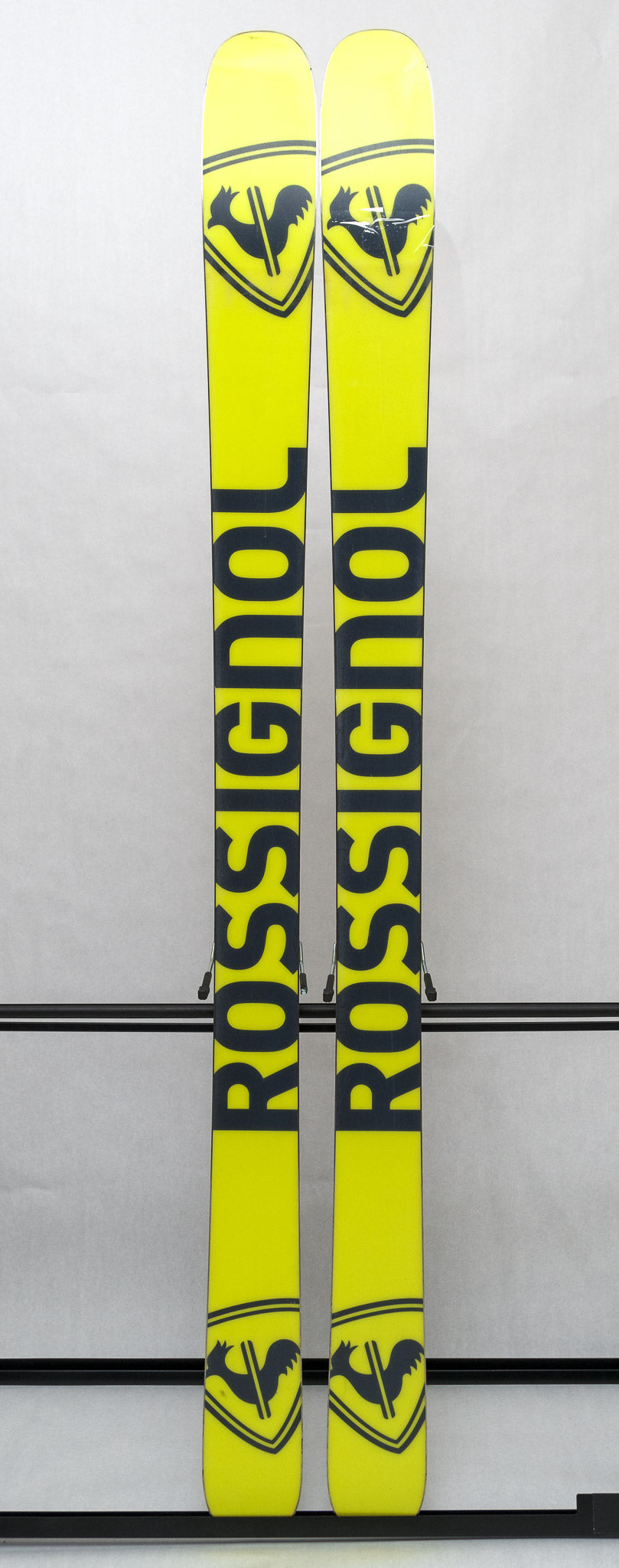 USED - Rossignol Black Ops Sender Ti with SPX 12 Bindings - A pair of skis featuring a sleek black design, with silver bindings and a subtle sheen on the surface.