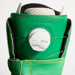 Vans snowboard boot close-up: BOA dial on green cuff with yellow stitched strap detail