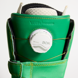 Vans snowboard boot close-up: BOA dial on green cuff with yellow stitched strap detail
