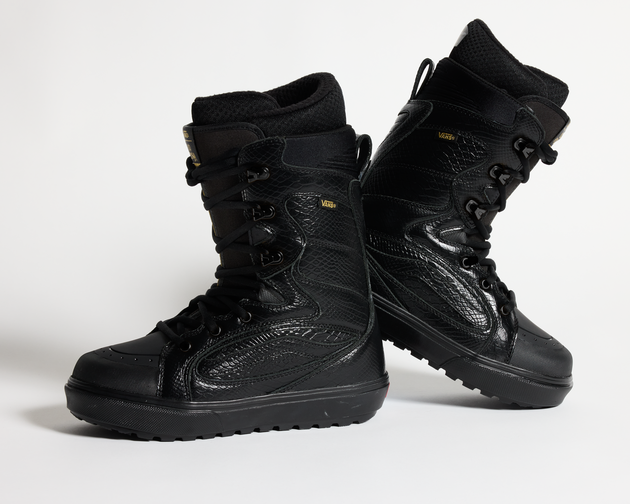 Pair of black lace-up snowboard boots with padded cuffs and patterned leather panels.
