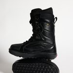 Vans black snowboard boots, high-top lace-up with padded collar and rugged tread sole.