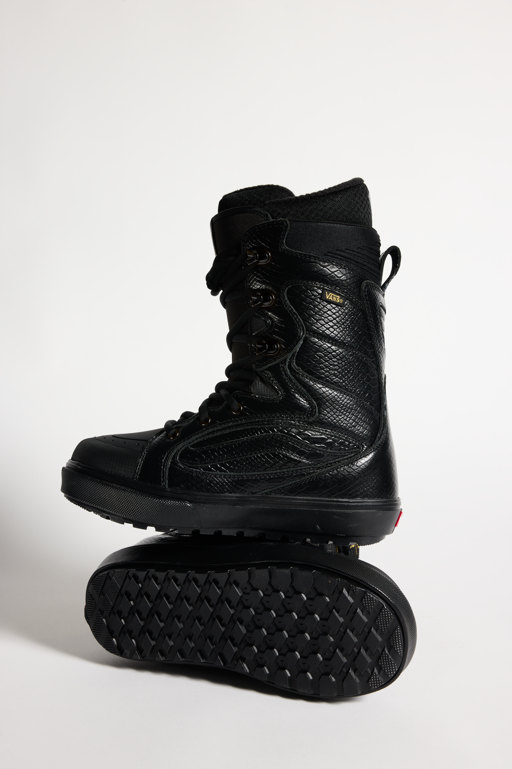 Vans black snowboard boots, high-top lace-up with padded collar and rugged tread sole.