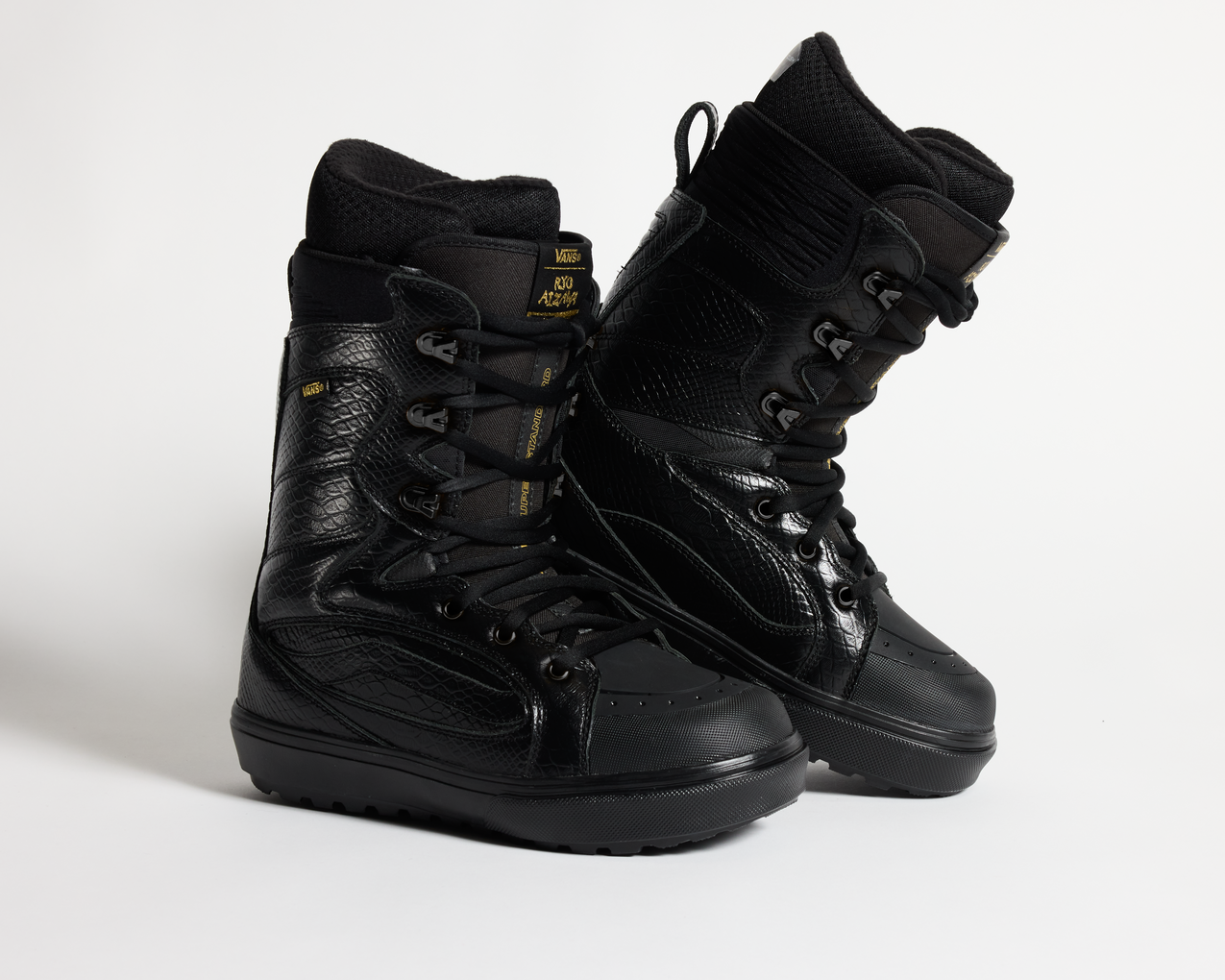 Black lace-up snowboard boots with side ankle straps and thick lugged outsole.