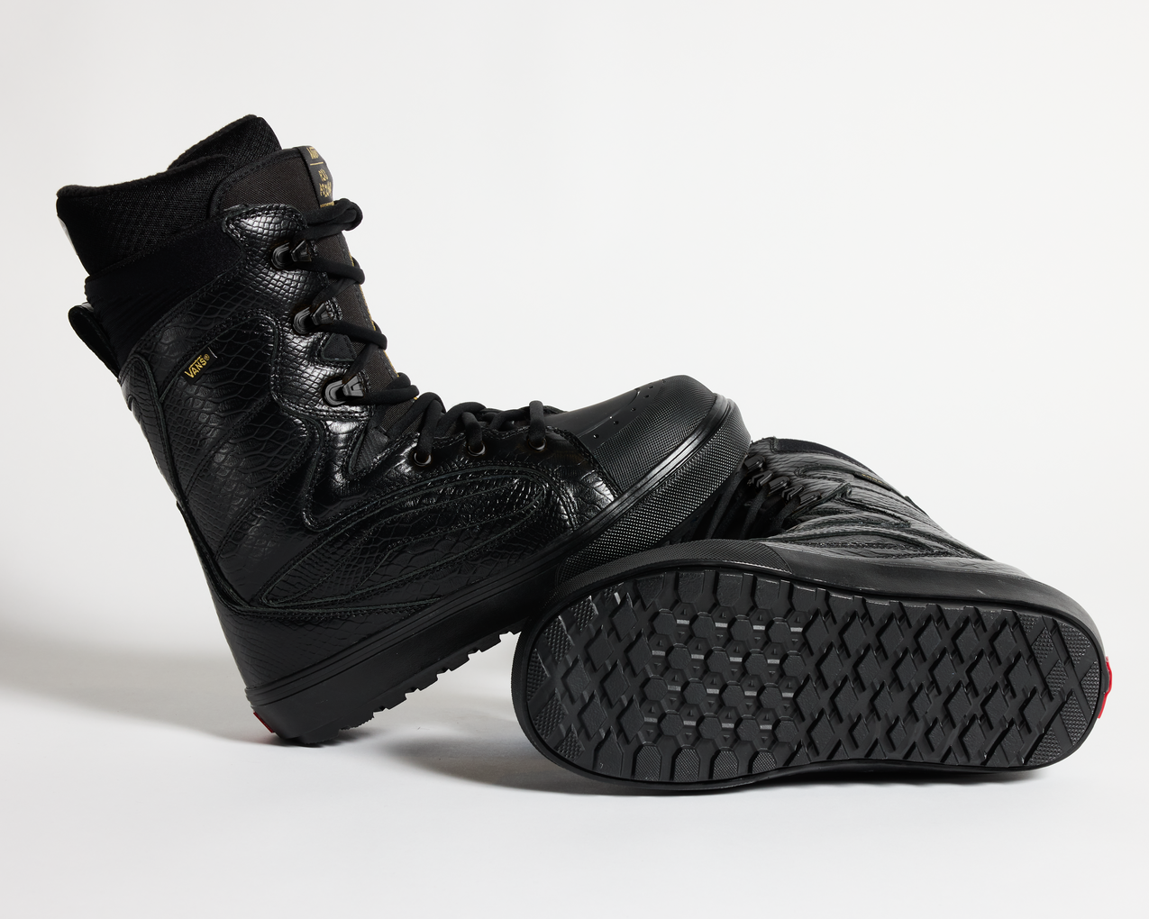 Black snowboard boot low-angle view showing lace-up top and textured tread outsole.