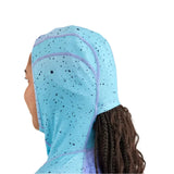 Airblaster Women's Classic Ninja Suit 2025 - A woman wearing a light blue ninja suit with black speckles and purple accents, facing left.