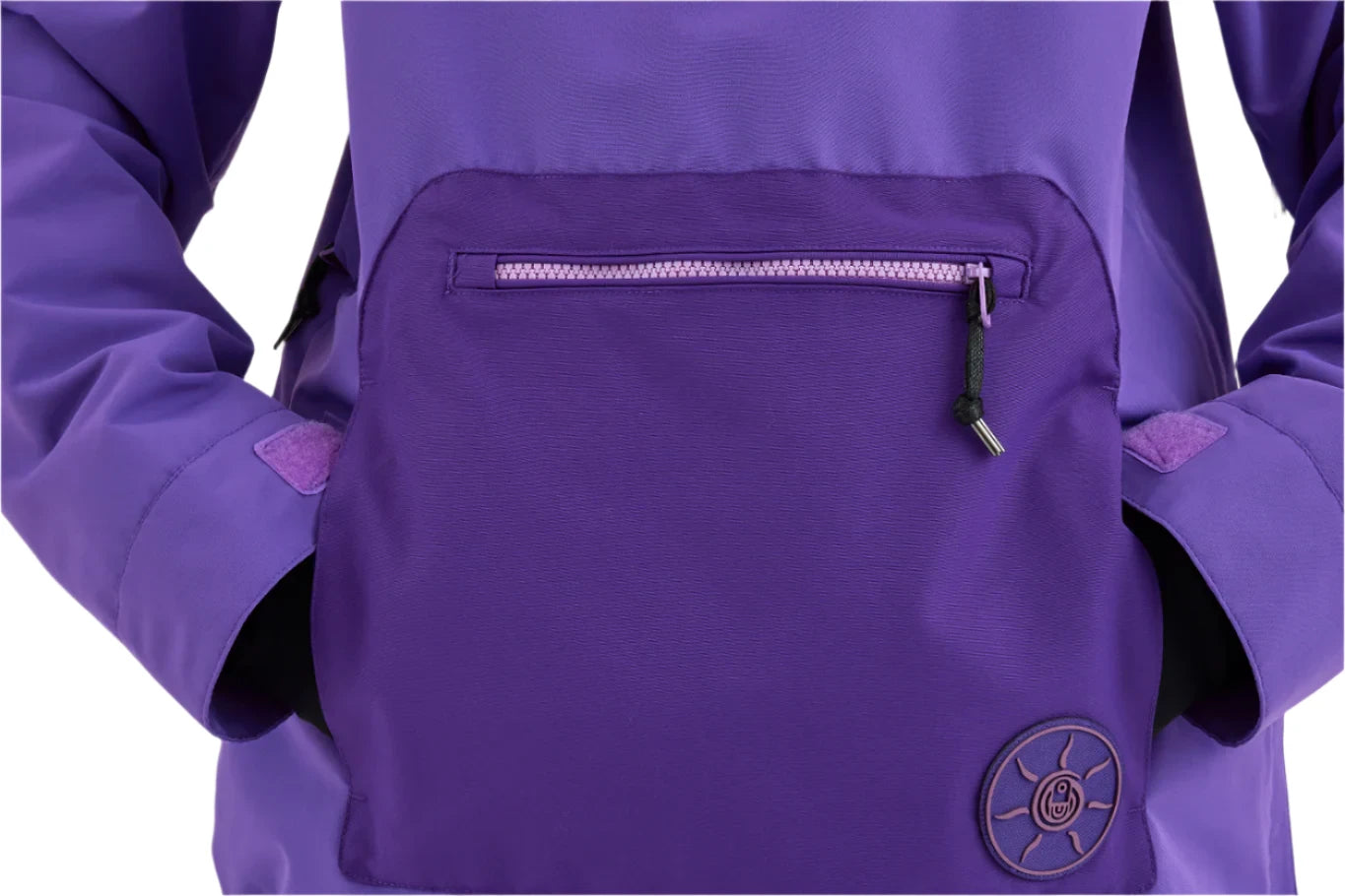 Airblaster Women's Nai Freedom Shell Pullover 2025 - A purple pullover with a zipper on the chest and two zippered pockets at the waist.