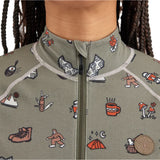 Airblaster Women's Hoodless Ninja Suit 2025 - A sage green onesie with a repeating pattern of cartoon-style illustrations, including skiers, snowboarders, and various winter-themed icons.