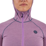 Airblaster Women's Merino Ninja Suit 2025 - A woman wearing a purple merino ninja suit with a hood, standing in front of a white background.