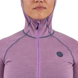 Airblaster Women's Merino Ninja Suit 2025 - A woman wearing a purple merino ninja suit with a hood, standing in front of a white background.