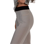 Whitespace Women's Graphene Midweight Base Layer Bottom 2024 - A pair of light gray base layer bottoms with a subtle horizontal stripe pattern and a small black logo on the left leg.