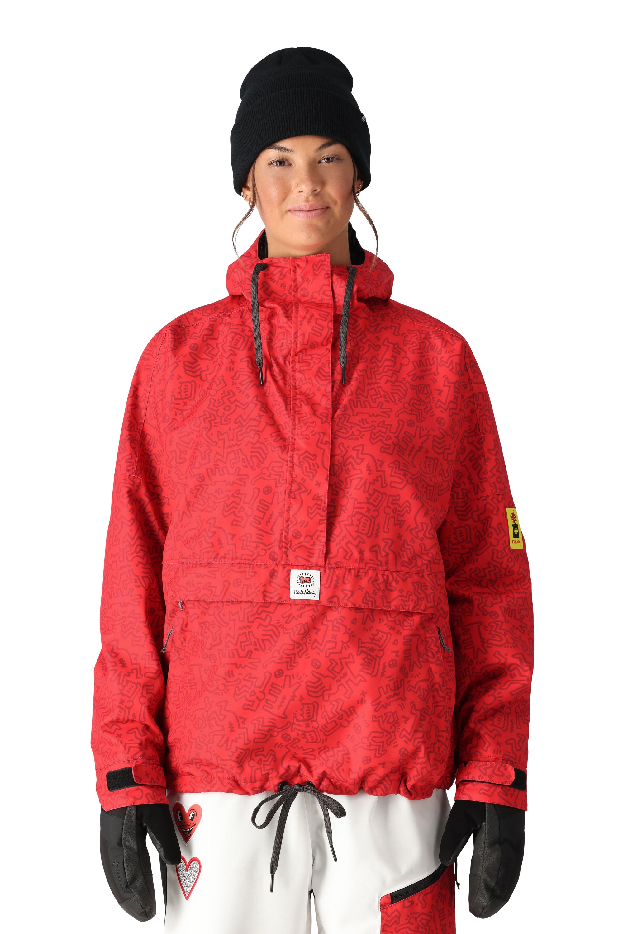 The 686 Women's Outline Shell Anorak has a red color with a black pattern and a hood.