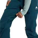 Burton Women's Avalon Stretch 2L Bib Pant 2025 - Dark blue bib pant with a white logo on the left leg and black zippers.